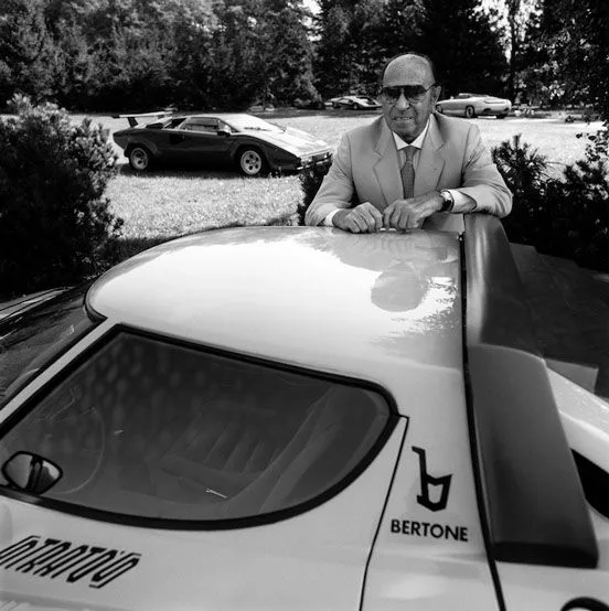 Carrozzeria Bertone founder Nuccio Bertone in front of the Lancia Stratos and Lamborghini Countach, two of his firm's landmark wedge-era designs.