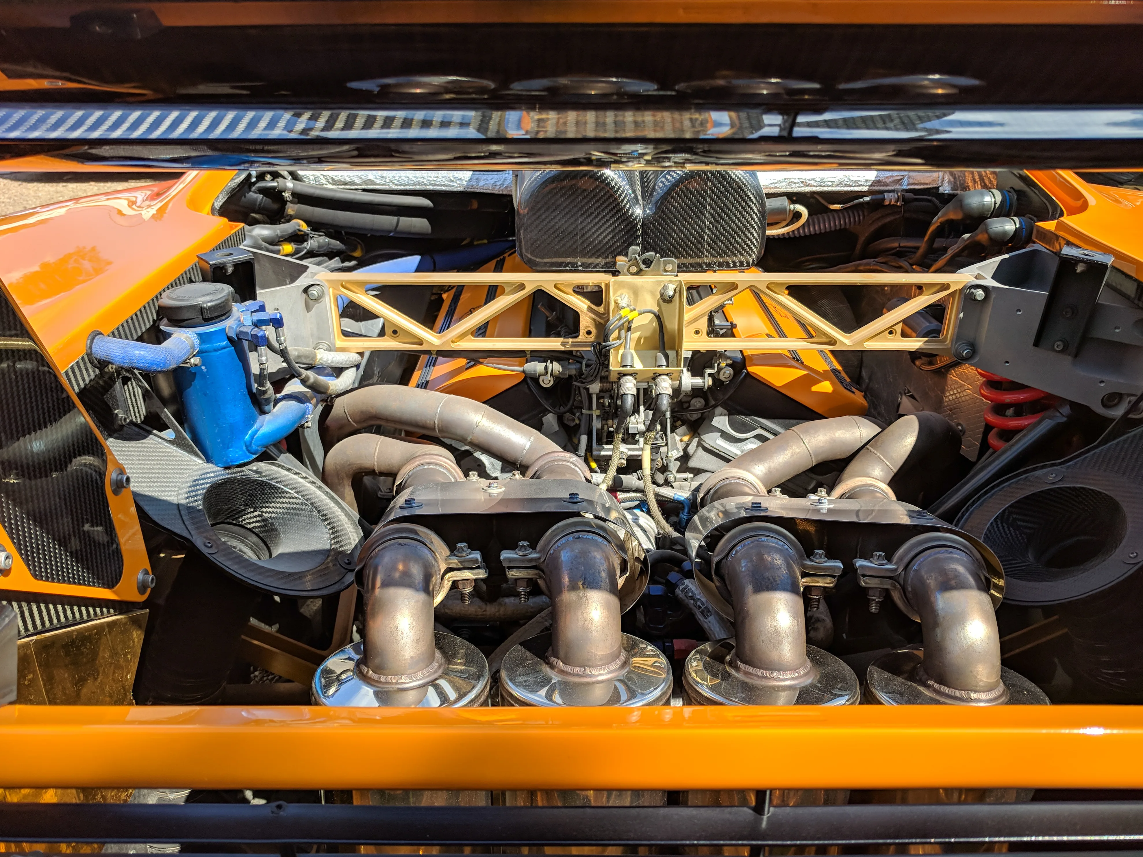 The BMW S70/2 V12 engine bay of a McLaren F1 LM, the gold-foil heat-shield lining Gordon Murray specified for thermal reflectivity is clearly visible.