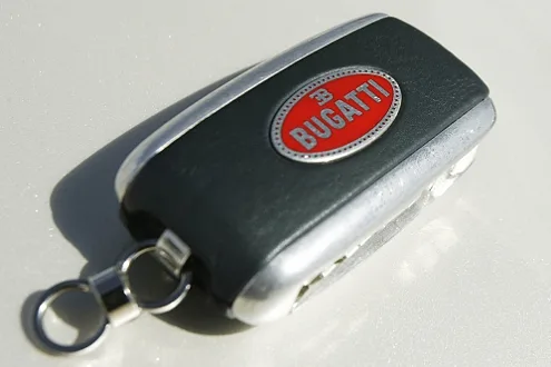 The Bugatti Veyron's second key, the mandatory 'top-speed key' that unlocks the 400 km/h mode by reconfiguring the active aero. A primary artifact of the car's engineering protocol.